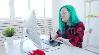 自由职业者或办公室工作的概念.. 年轻的女平面设计师，有彩色头发，在办公室或家里工作